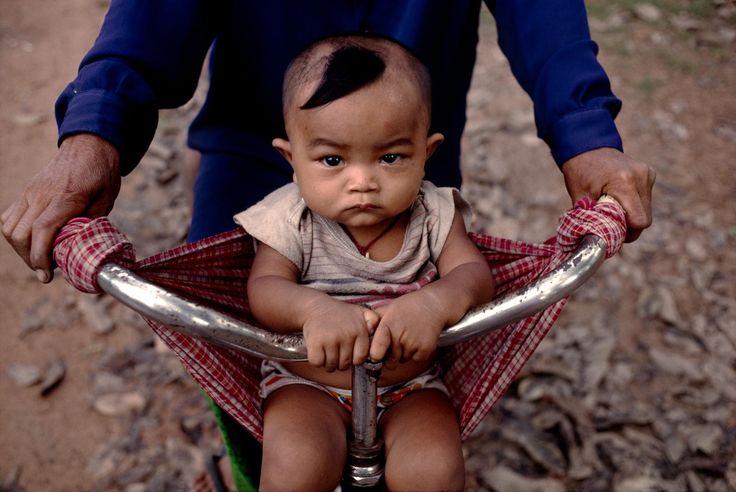 Baby in a bicycle sling, Cambodia